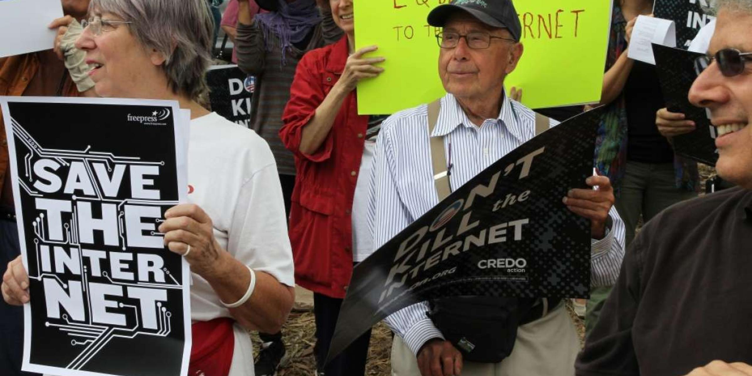 Woman holding Save Our Internet sign