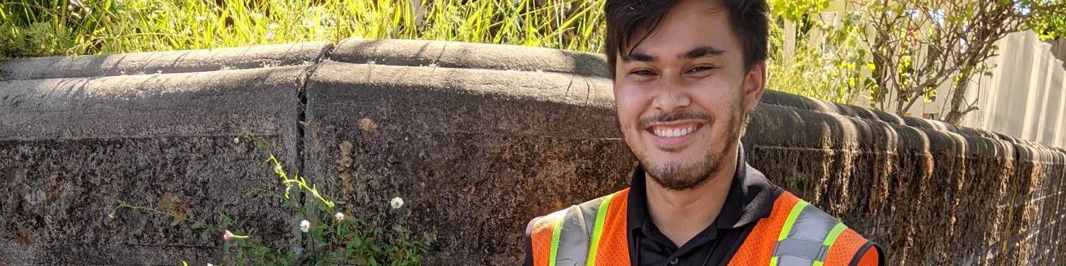 Sonic employee in orange safety vest holding tablet