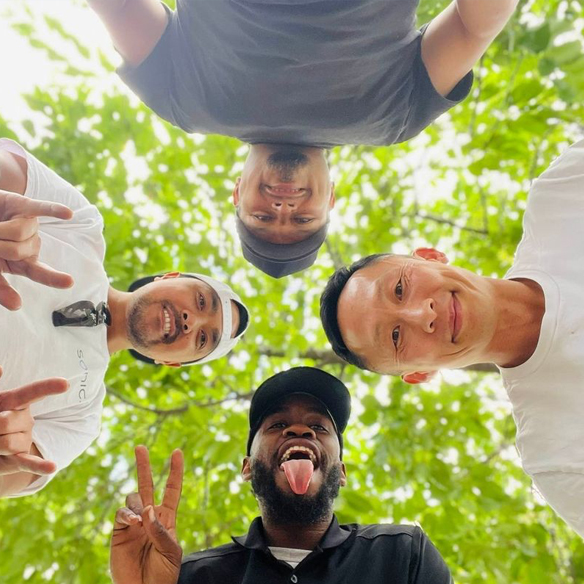 Four Sonic employees gathered around looking down at camera on the ground.