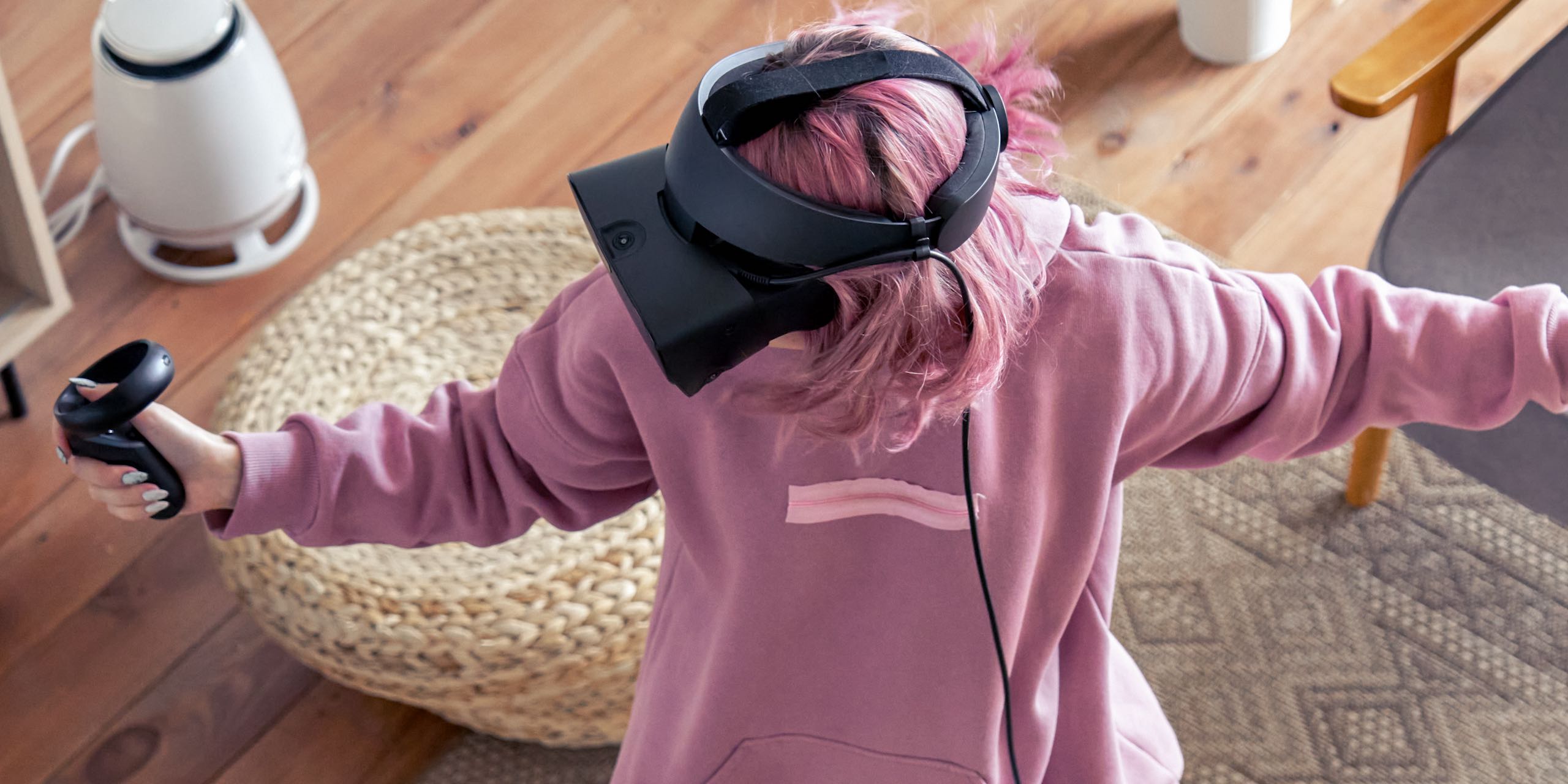 Girl with pink hair wearing vr headset goggles and holds controllers