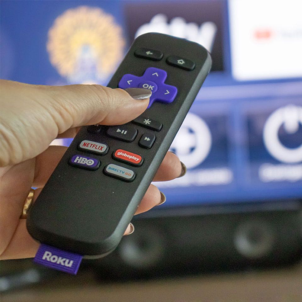 Roku remote control pointing at TV.