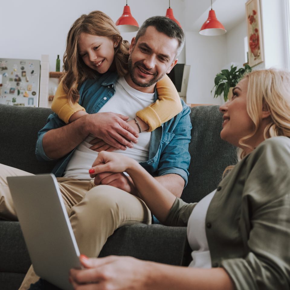 Family streaming tv on laptop at home.